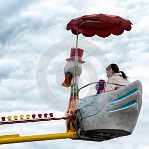 Mom and child in Children\'s carousel - swans - \