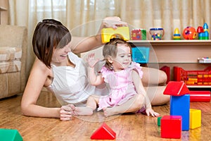 Mom and child daughter play block toys home