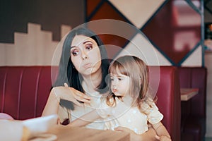 Mom and Child Feeling the Heat Sitting in Indoors Restaurant