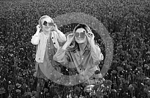 Mom with a child girl in a field of red poppies enjoys nature. Mother and little daughter in the poppy field. A young