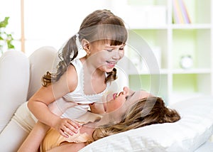 Mom and child having fun in bed
