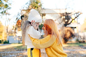 Mom and child having fun together. Autumn fashion, lifestyle. Stylish family on autumn walk