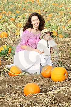 Mom and Child Sitting in a Pumpkin Patch