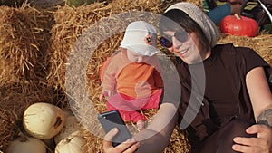 Mom with a child takes a selfie in countryside, using phone for take a picture