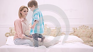 Mom and child talking in bedroom. Mother and child son play in bed. Motherhood and parenting, happy childhood.
