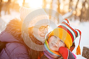 Mom and child in winter wonderland scene. Mother and baby in wintertime magic. Family on a walk in the Christmas and New Year