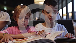 Mom with children chooses pizza in a cafe and have a fun