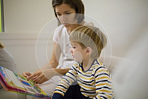 Mom with children reads a book before going to bed