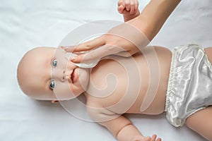 Mom cleaning up and wipe body baby by wet tissue when changing nappies or diaper and wiping the hands or face or leg, Personal photo