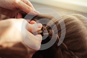 Mom is combing her daughter`s hair. Taking care of baby`s hair. The concept of a happy childhood and a good attitude towards