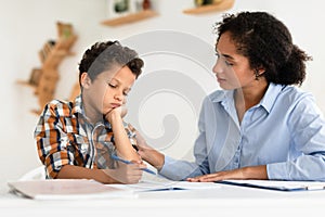 Mom Comforting Unhappy Schoolboy Son Having Issue With Homework Indoors
