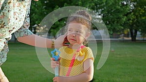 Mom comforts the little sad crying girl in garden. Slow motion. Children.