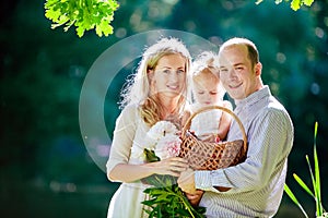 Mom, dad and daughter happy smile on the background of the fores