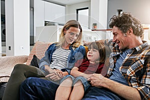 Mom, dad and happy family relax on sofa in living room with love, quality time and chat together at home. Young boy