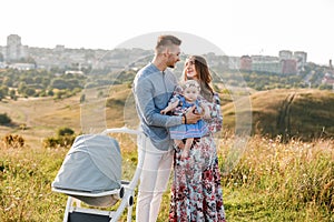 Mom, dad and little girl having fun outdoors in the grass on summer day. mother`s, father`s and baby`s day. Happy family for a