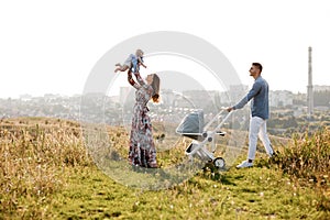 Mom, dad and little girl having fun outdoors in the grass on summer day. mother`s, father`s and baby`s day. Happy family for a