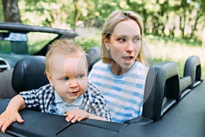 Mom, dad and little son in a convertible car. Summer family road trip to nature