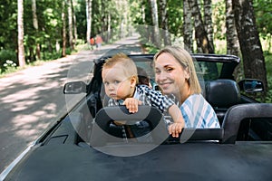 Mom, dad and little son in a convertible car. Summer family road trip to nature