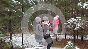 Mom and dad play and throw the child in the winter forest park. Portrait of a happy family in the fresh air, walking in