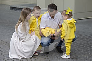 Mom and dad show the children a newborn baby