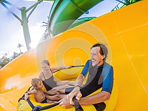 Mom, dad and son at the water park eating along the roller coaster