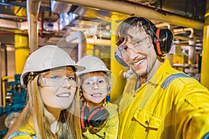 Mom, Dad and Son in a yellow work uniform, glasses, and helmet in an industrial environment, oil Platform or liquefied