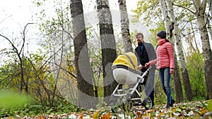 Mom and Dad are walking in the woods with a newborn baby