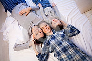 Mom dad and son in the morning lying on the bed at home in a good mood