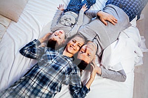 Mom dad and son in the morning lying on the bed at home in a good mood