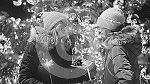 Mom and daughter with bengal fire near the Christmas tree.