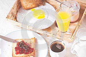 Mom and daughter breakfast in bed on a white blanket