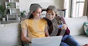 Mom and daughter buying online using laptop