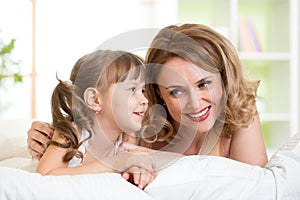 Mom with daughter converse lying on bed