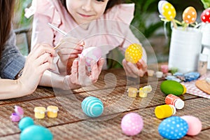 Mom and daughter decorating Easter eggs.