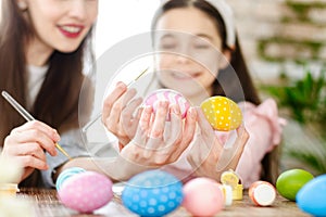 Mom and daughter decorating Easter eggs.