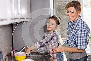 Mom and daughter do the dishes