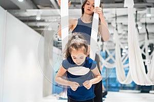 Mom and Daughter are doing yoga. Family in a gym.