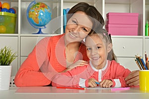 Mom and daughter draw at home together.