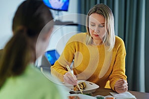 Mom and daughter eat sushi