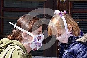 Mom and daughter with facemasks against coronavirus.
