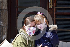 Mom and daughter with facemasks against coronavirus. photo