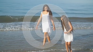 Mom and daughter go by the sea