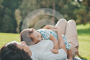 Mom and daughter in happines laying on a grass