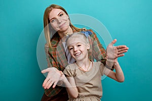 Mom and daughter havin fun in a blue studio isolated.
