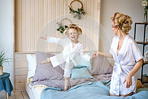 Mom and daughter having fun on the bed