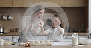 Mom and daughter having fun while cooking in the kitchen