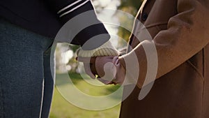 Mom daughter holding hands in sunny park together closeup. Happy mother child.