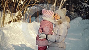 Mom and daughter hug in the suburbs in winter.