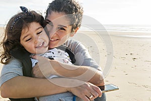 Mom and daughter hugged happy on the beach