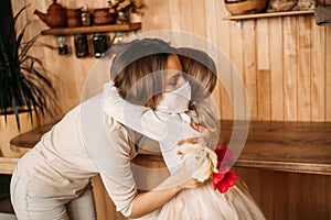 Mom and daughter hugging in masks. Family quarantined. Mother`s day at home